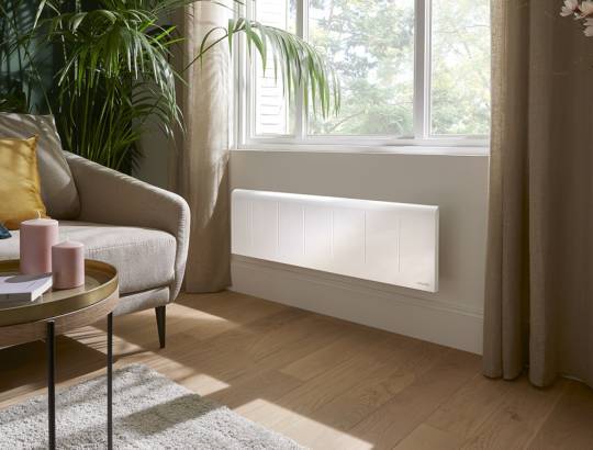 Radiateur fonte Atlantic Nirvana Neo Plinthe blanc installé sous fenêtre dans salon moderne